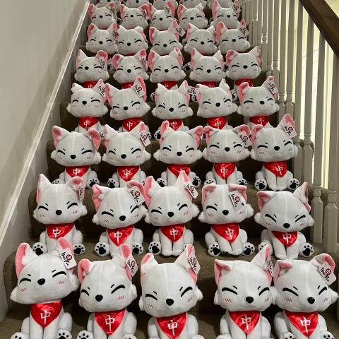 A pack of Inari-kun plushies sitting on the stairs
